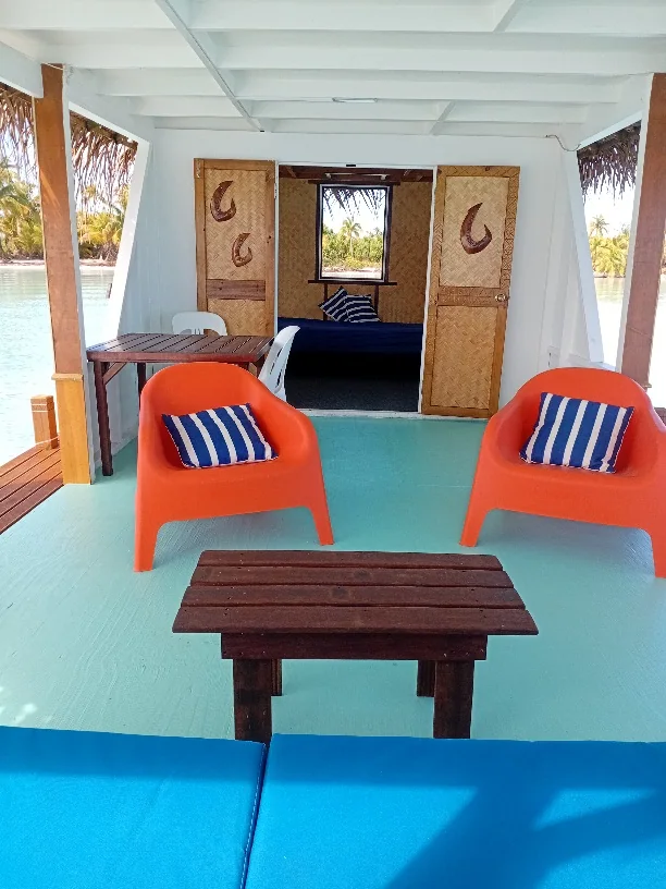 Orange lounge chairs and a timber table facing the private changing room on the floating lounge.